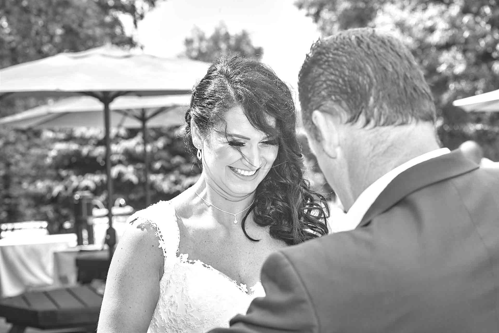 Bride with a big smile on her face as her husband puts the ring on her finger after the wedding vows.